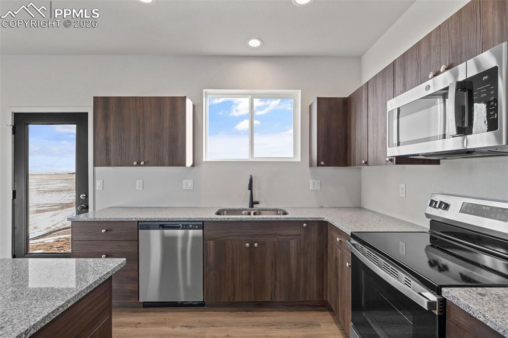 24615 Big Springs Road Calhan, CO 80808 - Photo 8 of 40 a kitchen with stainless steel appliances granite countertop a sink stove and cabinets