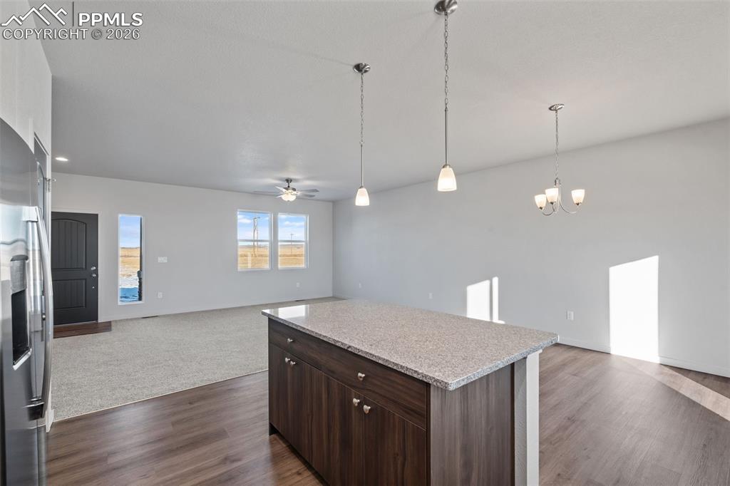 24615 Big Springs Road Calhan, CO 80808 - Photo 9 of 40 a kitchen with kitchen island a sink dishwasher a refrigerator and wooden floor
