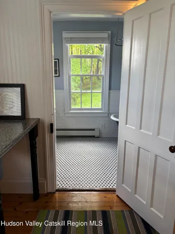 a bedroom with a bed a chair and next to a window