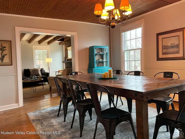 a view of a hallway with wooden floor and furniture