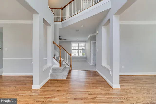 a view of a hallway with wooden floor and staircase
