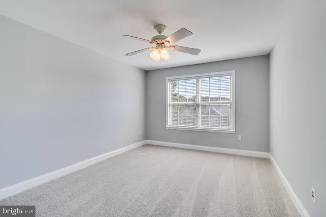 a view of a livingroom with a ceiling fan and window