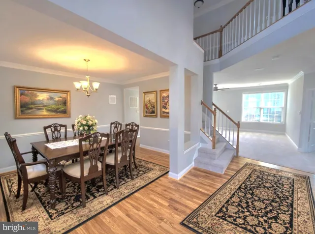 a dining room with wooden floor and a rug