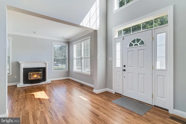 an empty room with windows a fireplace and wooden floor