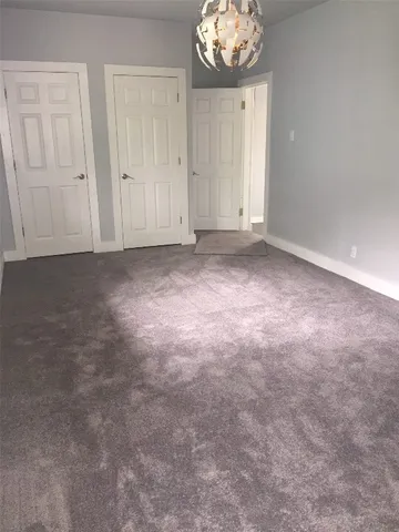 a view of an empty room and chandelier