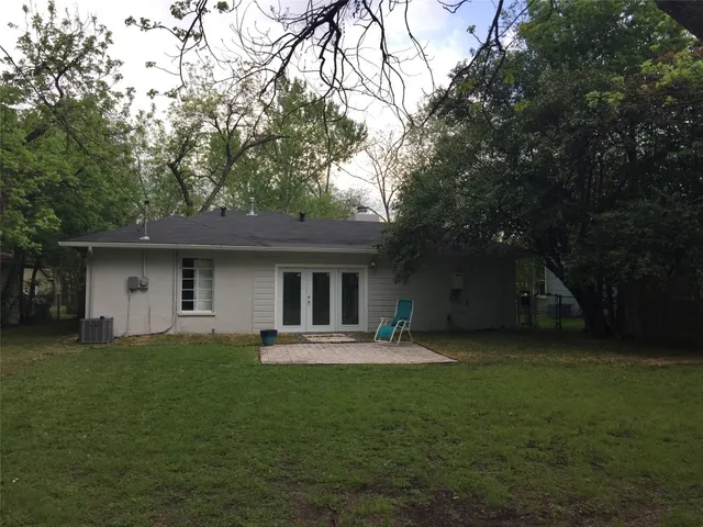 a front view of a house with a garden and trees