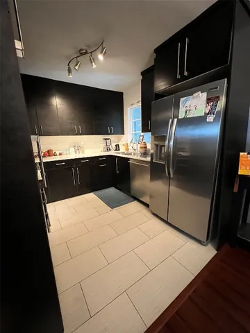 a large kitchen with a stove and a refrigerator