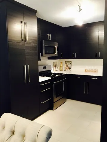 a kitchen with stainless steel appliances kitchen island granite countertop a refrigerator and a sink