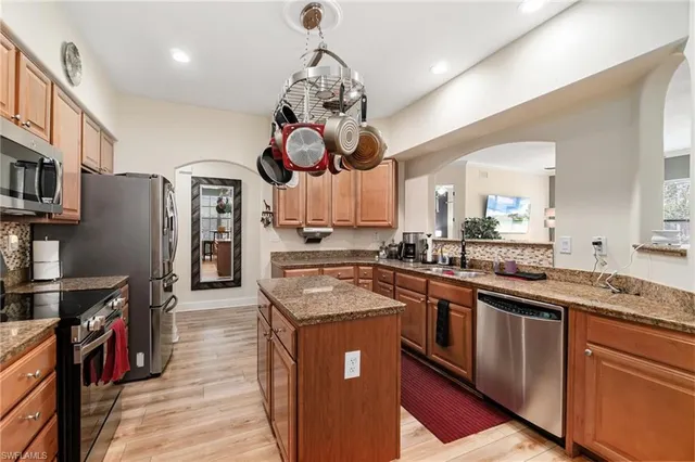 a kitchen with stainless steel appliances granite countertop a sink a stove and a refrigerator