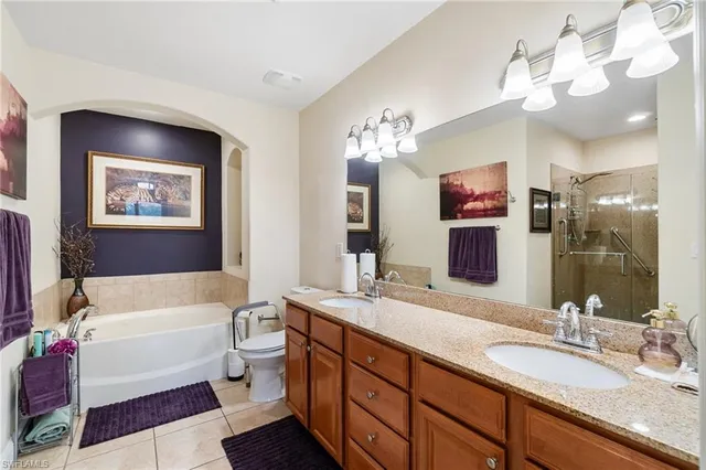 a spacious bathroom with a granite countertop sink mirror and bathtub