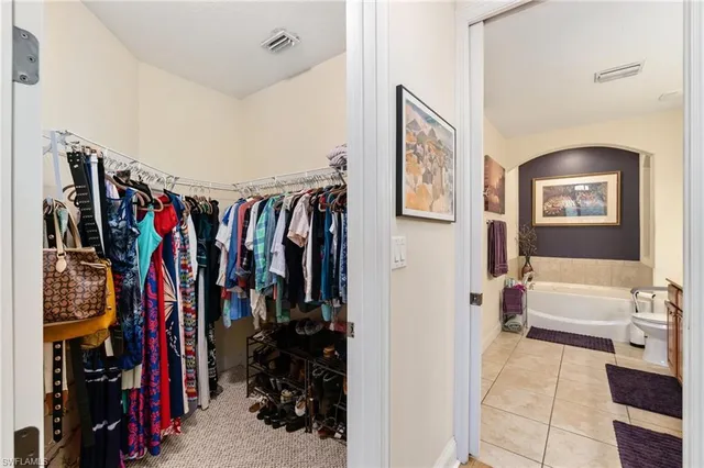 a view of walk in closet with clothes and shoes