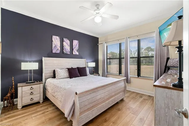 a bedroom with a large bed and a flat tv screen on dresser