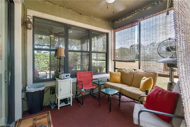 a living room with furniture and a floor to ceiling window