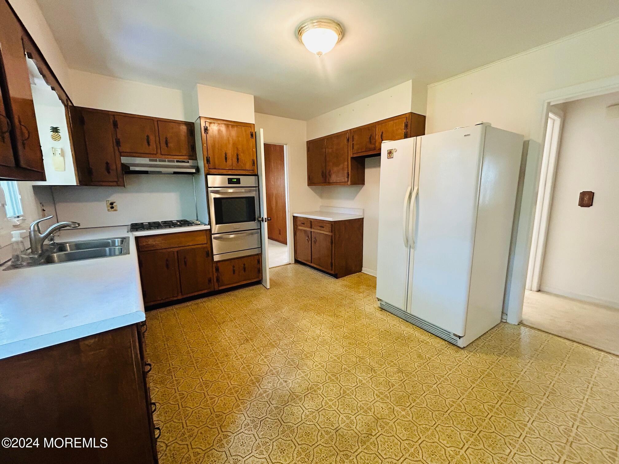 2402 Anne Terrace Wall, NJ 07719 - Photo 11 of 25 a kitchen with stainless steel appliances a refrigerator and a stove top oven