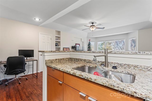 a kitchen with granite countertop a sink a counter top space and cabinets