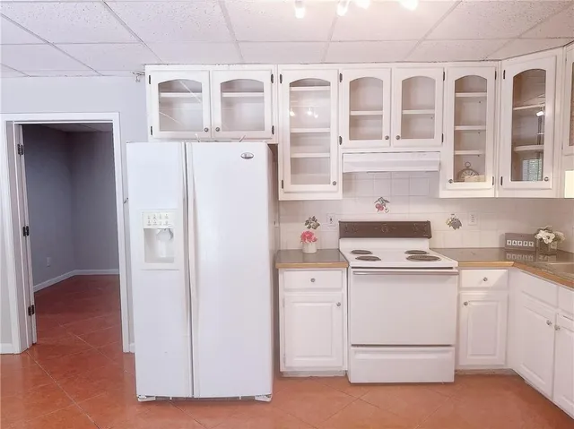 a kitchen with white cabinets and white appliances