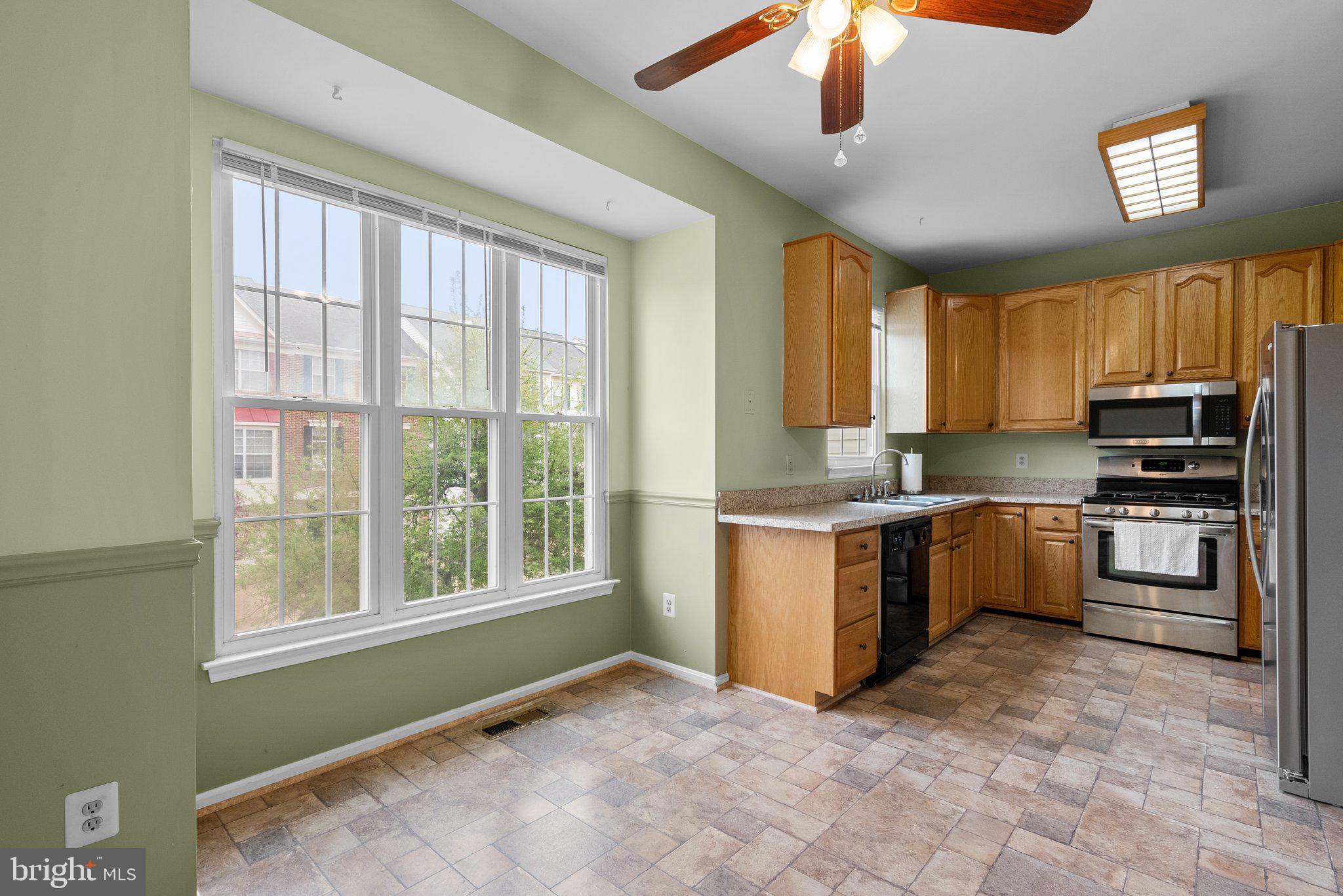 21937 Thompson Square Sterling, VA 20166 - Photo 13 of 48 a kitchen with a refrigerator window and cabinets