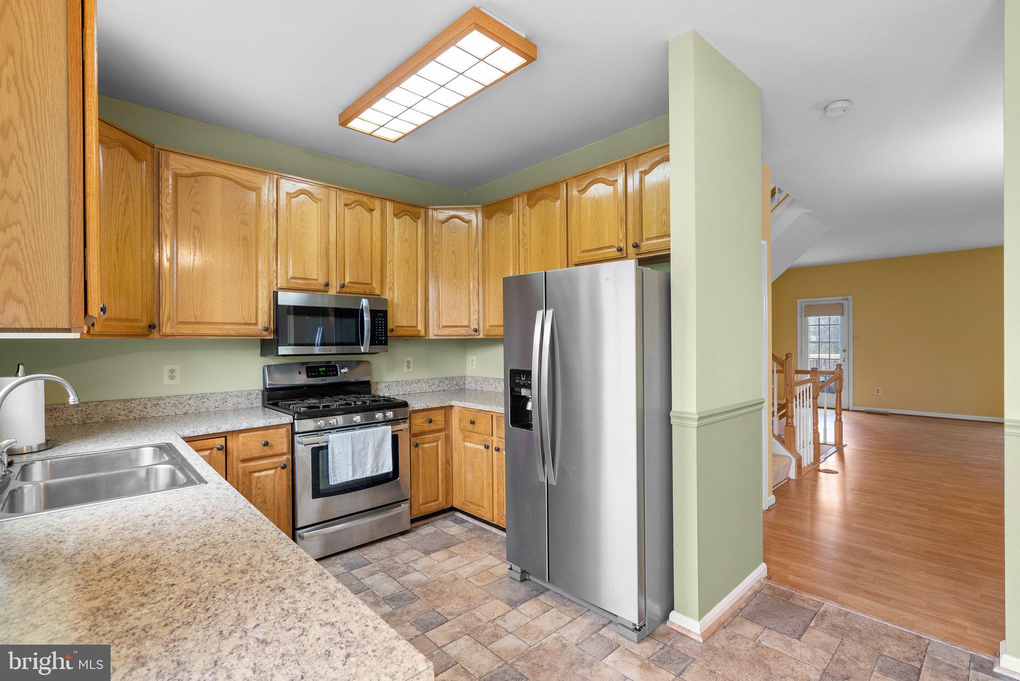 21937 Thompson Square Sterling, VA 20166 - Photo 15 of 48 a kitchen with stainless steel appliances granite countertop a refrigerator a stove top oven a sink and dishwasher