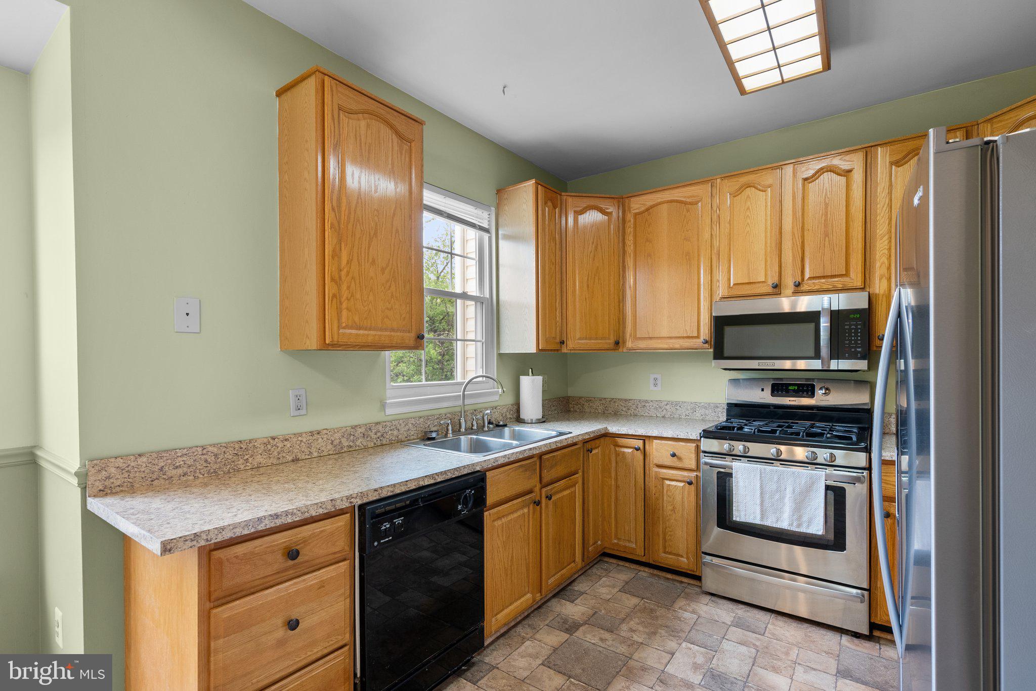 21937 Thompson Square Sterling, VA 20166 - Photo 16 of 48 a kitchen with a sink stove top oven and cabinets