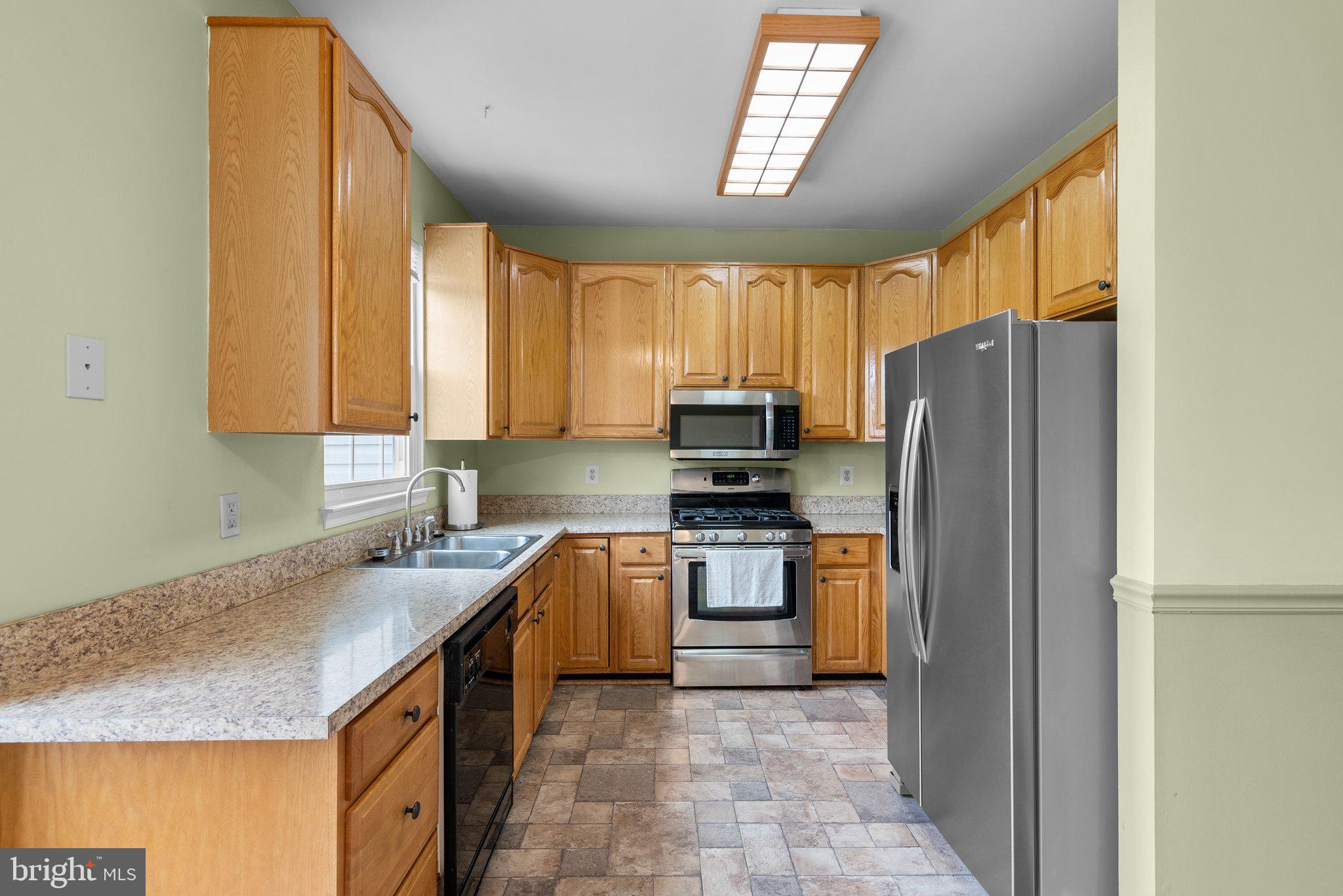 21937 Thompson Square Sterling, VA 20166 - Photo 17 of 48 a kitchen with stainless steel appliances granite countertop a refrigerator sink and stove