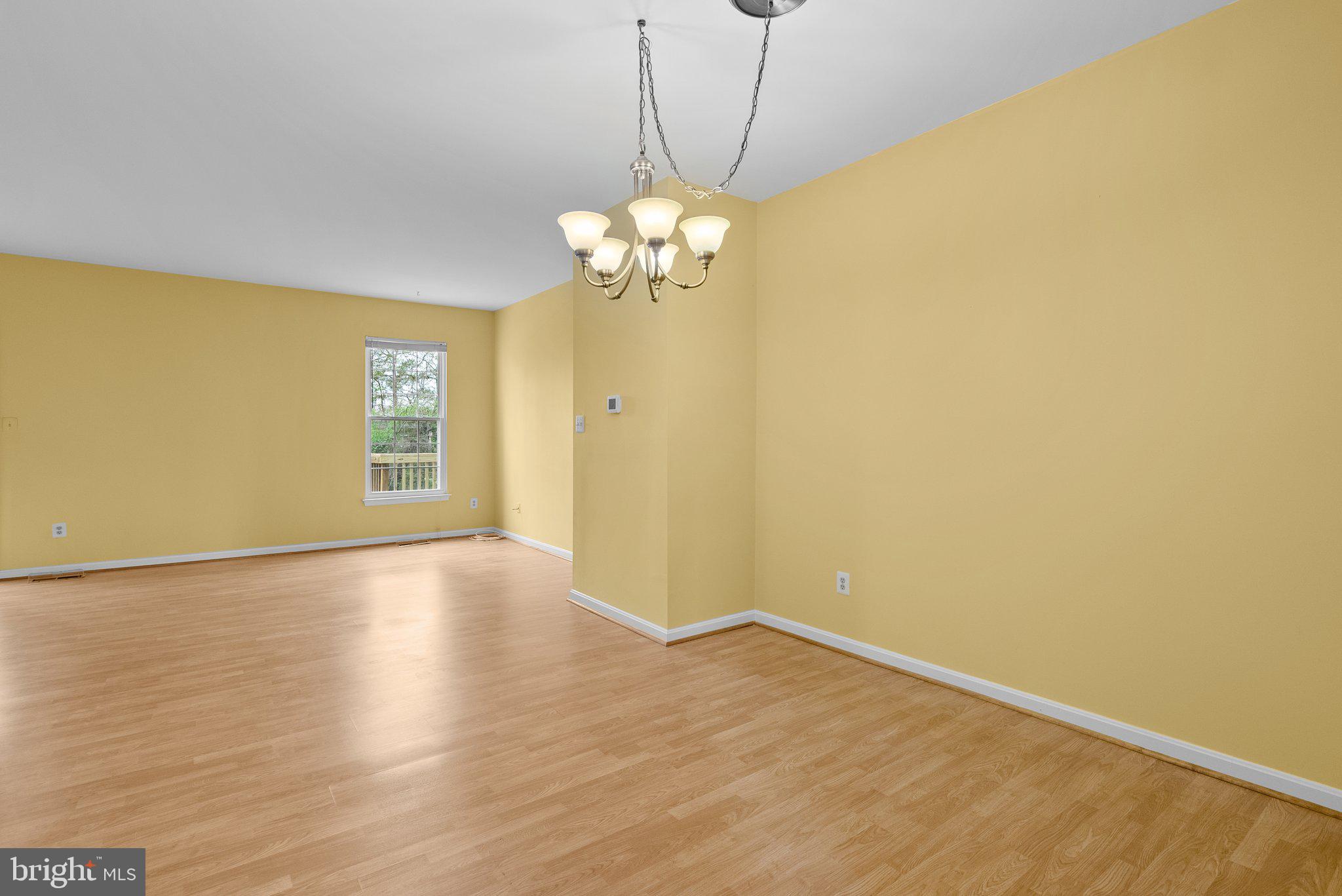 21937 Thompson Square Sterling, VA 20166 - Photo 23 of 48 a view of a kitchen with wooden floor and a chandelier