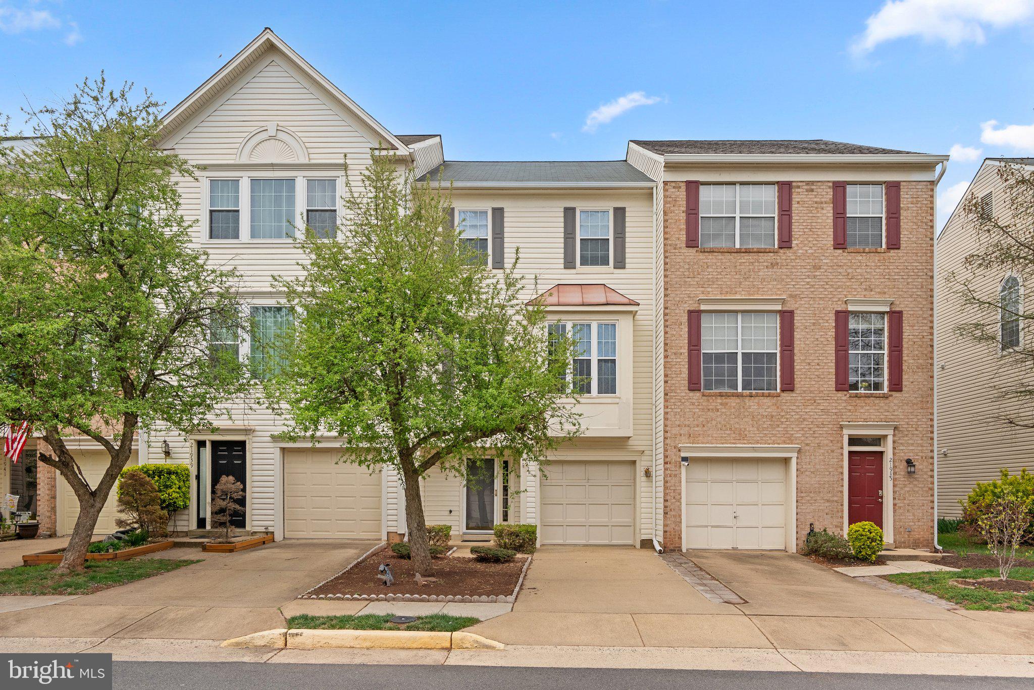 21937 Thompson Square Sterling, VA 20166 - Photo 3 of 48 a front view of a house with yard and parking