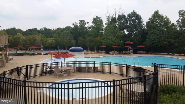 21937 Thompson Square Sterling, VA 20166 - Photo 44 of 48 a view of a swimming pool with a patio and a yard