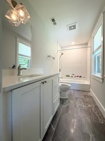 a bathroom with a sink a toilet and a mirror