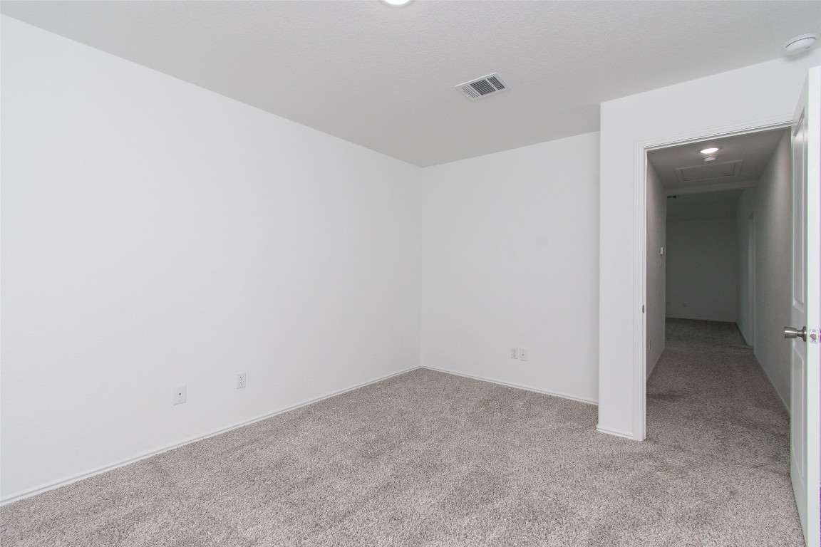 9101 Daisy Cutter Crossing Georgetown, TX 78626 - Photo 13 of 28 Unfurnished room with light colored carpet and a smoke detector