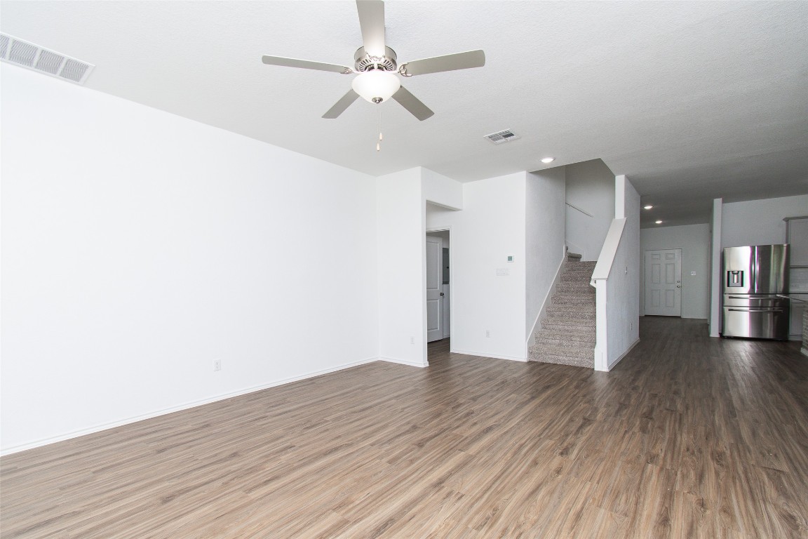 9101 Daisy Cutter Crossing Georgetown, TX 78626 - Photo 2 of 28 Unfurnished living room featuring wood finished floors, stairs, a ceiling fan, and recessed lighting