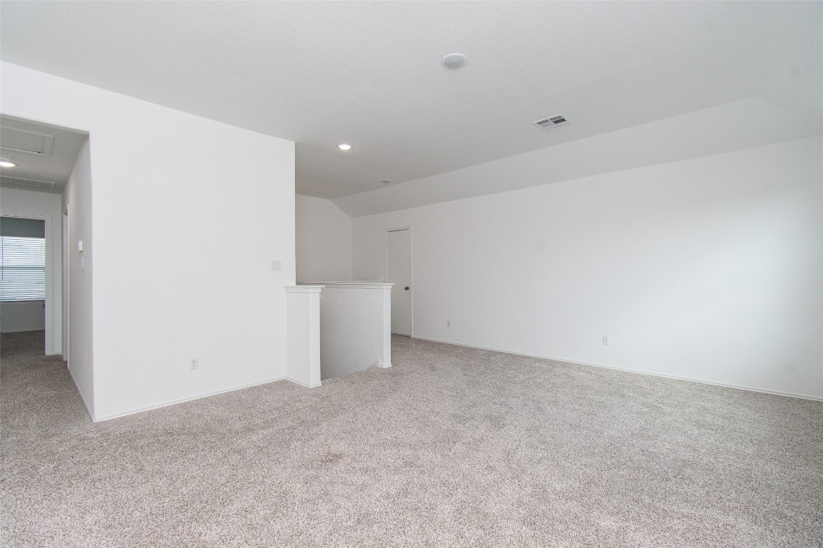 9101 Daisy Cutter Crossing Georgetown, TX 78626 - Photo 22 of 28 Unfurnished living room with light colored carpet, recessed lighting, and lofted ceiling