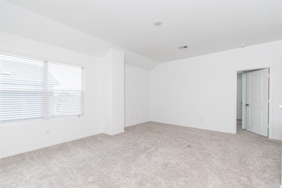 9101 Daisy Cutter Crossing Georgetown, TX 78626 - Photo 23 of 28 Unfurnished room featuring light colored carpet and lofted ceiling