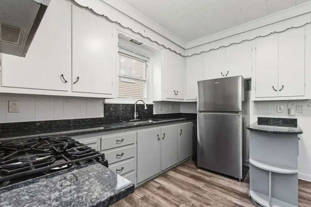 a kitchen with granite countertop white cabinets and white appliances
