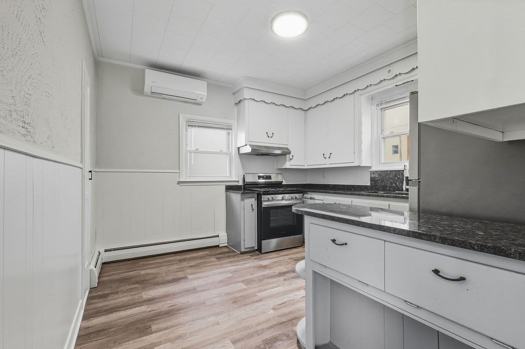 271 Mulberry Street Fall River, MA 02721 - Photo 30 of 30 a kitchen with granite countertop white cabinets and wooden floor