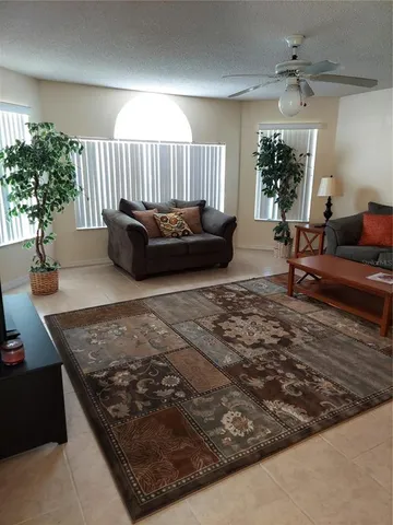 a living room with a couch and a potted plant