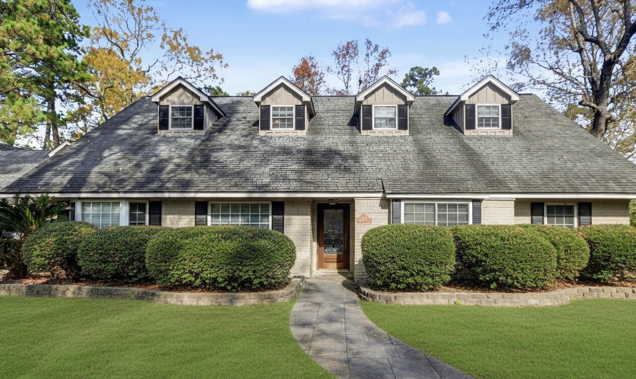 1431 Walnut Lane Houston, TX 77339 - Photo 4 of 44 Front elevation with dormer windows, mature landscaping, and a defined entry