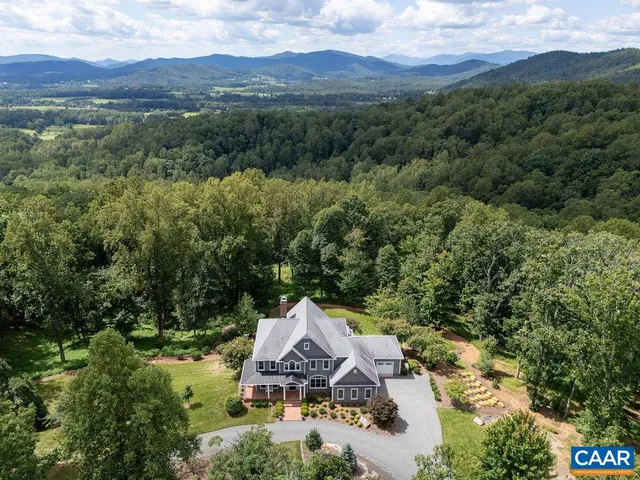 an aerial view of a house with a mountain in the background