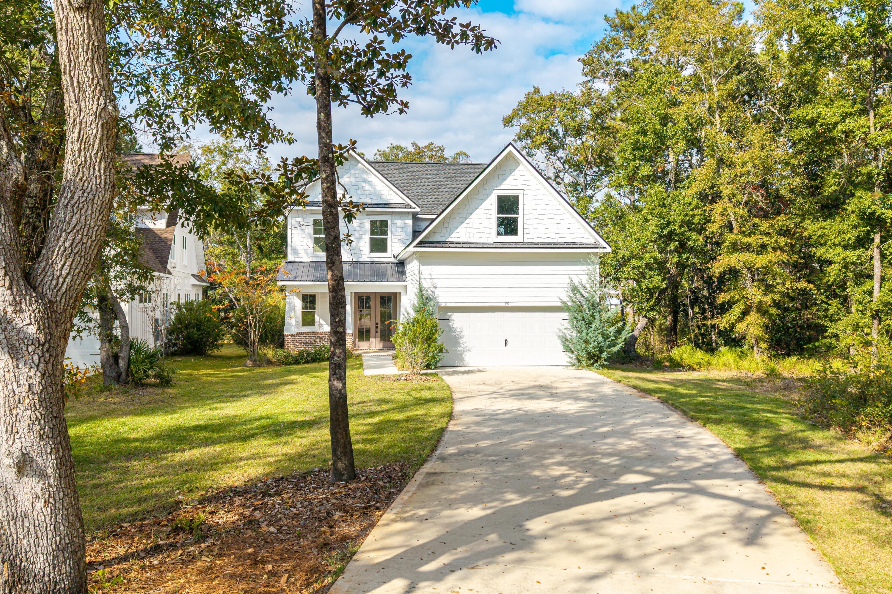 a front view of a house with a yard and trees