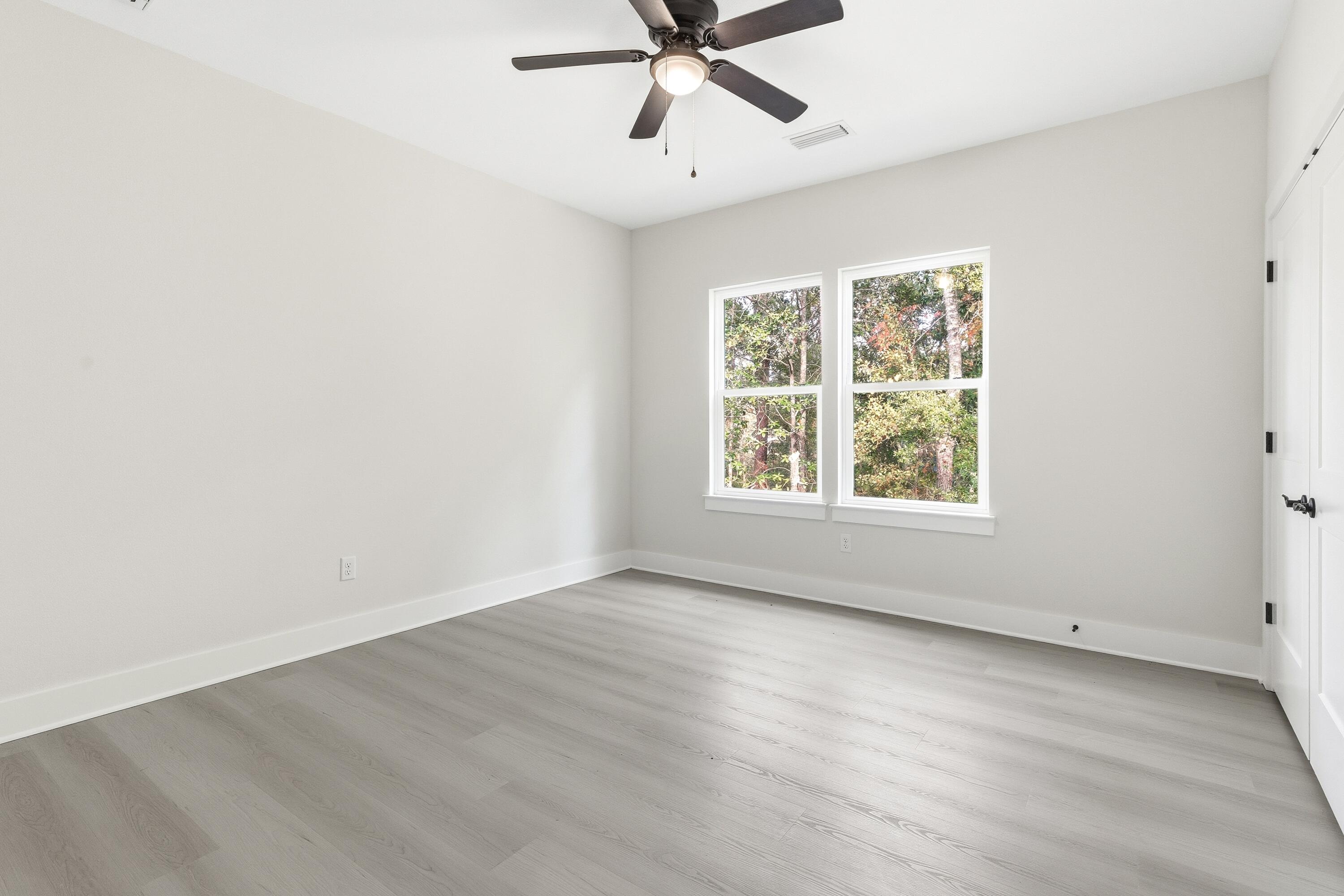 151 Redfish Pt Drive Freeport, FL 32439 - Photo 26 of 40 an empty room with wooden floor fan and windows