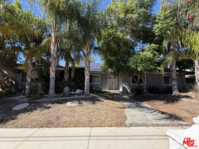 a view of a house with a yard and large trees