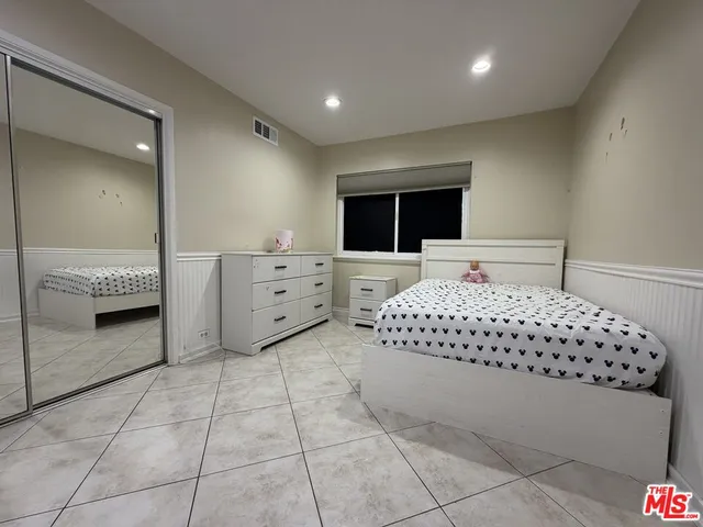 a bedroom with a large bed and a dresser