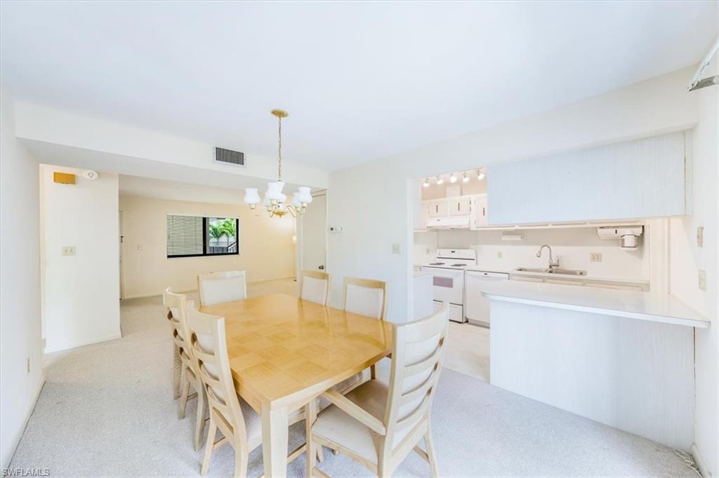 788 Park Shore Drive, Unit E20 Naples, FL 34103 - Photo 12 of 37 a kitchen with a table and chairs in it