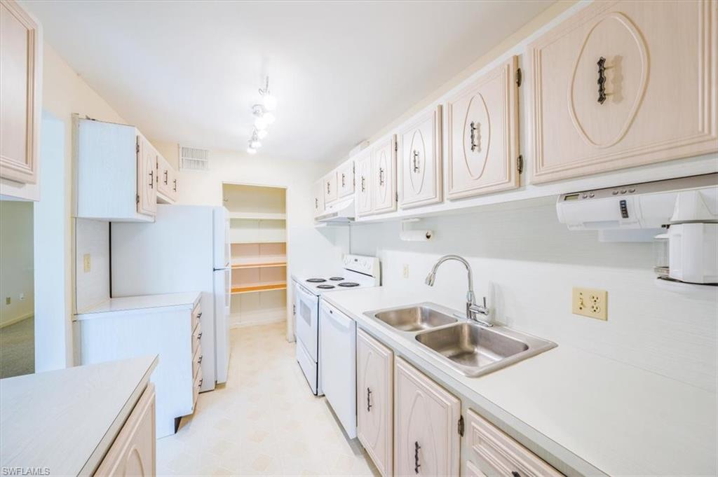 788 Park Shore Drive, Unit E20 Naples, FL 34103 - Photo 13 of 37 a kitchen with cabinets a sink and a stove