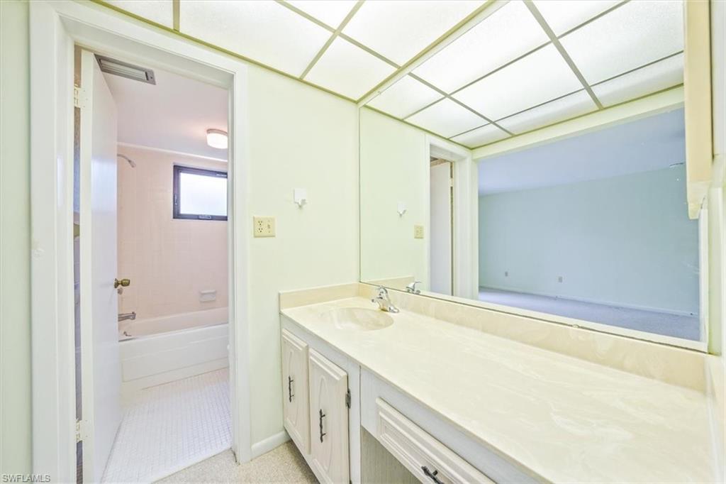 788 Park Shore Drive, Unit E20 Naples, FL 34103 - Photo 20 of 37 a bathroom with a granite countertop sink and a bathtub