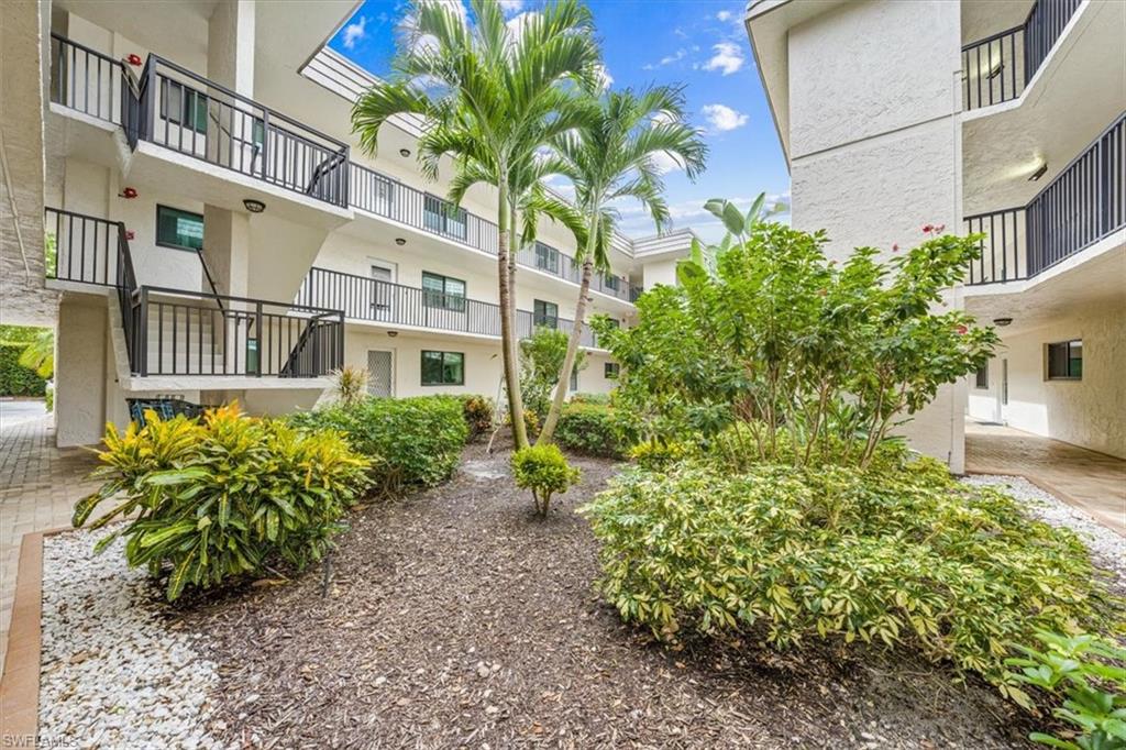 788 Park Shore Drive, Unit E20 Naples, FL 34103 - Photo 3 of 37 a view of a garden with a building