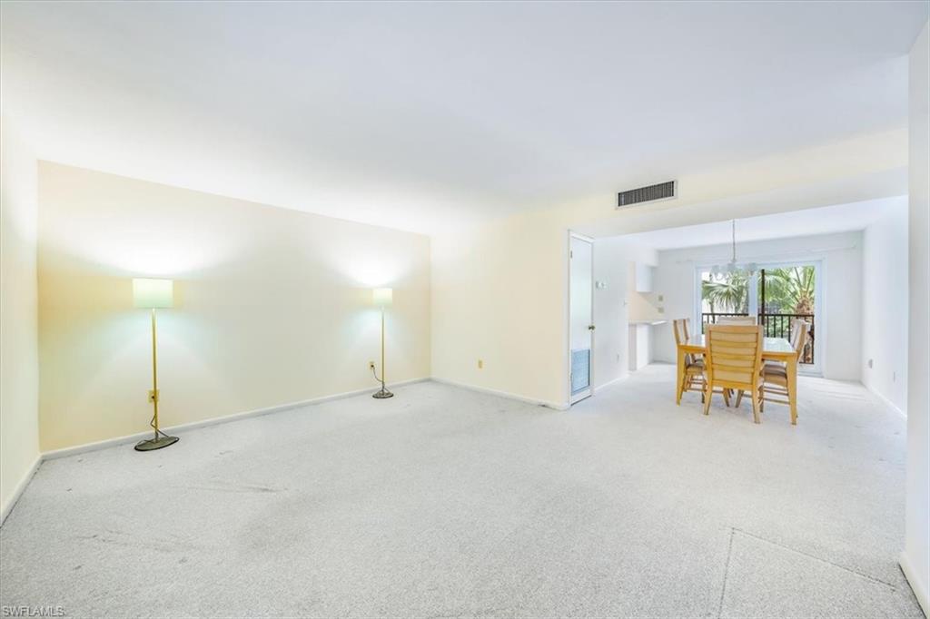 788 Park Shore Drive, Unit E20 Naples, FL 34103 - Photo 6 of 37 an empty room with a table and chairs