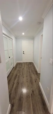 a bedroom with a bed wooden floor and a table