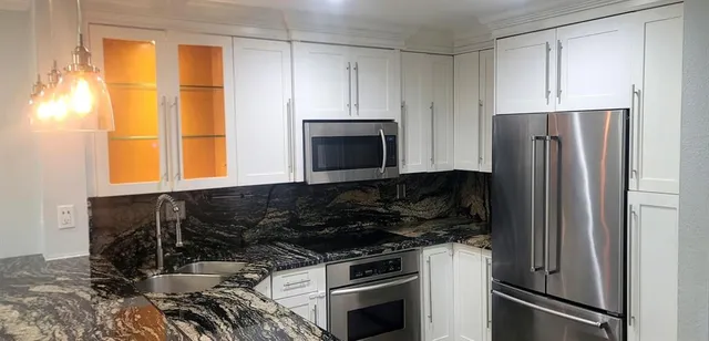 a kitchen with granite countertop a sink and cabinets
