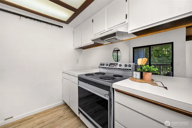 a kitchen with a stove and a wooden floor