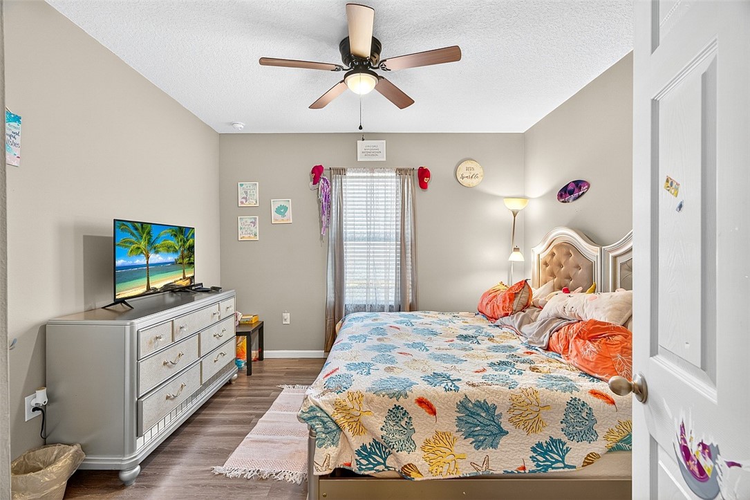 233 Periwinkle Drive Sebastian, FL 32958 - Photo 18 of 34 a bedroom with a bed and a flat tv screen on dresser